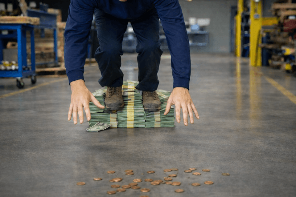AI depiction of a man in a warehouse tripping over dollars to pick up pennies
